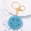 Macro di portachiavi con faccina sorridente in strass azzurro e dettagli metallici dorati - Ciondolo faccina sorridente azzurro