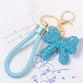 Dettaglio del portachiavi a fiocco con strass blu e cinturino in pelle intrecciata azzurra - Fiocco Blu Chiaro Con Corda (Colore 2)
