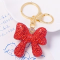 Detailed macro view of red rhinestone bow keychain with golden metal clasp and ring - Red Rhinestone Bowknot Pendant (Color 1)