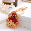 Dettaglio portachiavi rospo dorato con strass rossi e base con moneta tradizionale - Rosso