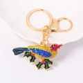 Close-up of golden bird keychain with colorful rhinestones and green enamel leaf details - Multicolor Bird Style (Color 3)