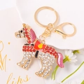 Close-up of crystal-encrusted horse keychain with red enamel and golden lobster clasp - Red
