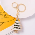 Detailed close-up of a sparkling Christmas tree keychain with colorful enamel and rhinestones - Green and White