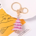 Detailed close-up of pink enamel Christmas tree keychain with sparkling rhinestones - Pink