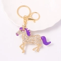 Sparkling crystal pony keychain in gold metal with purple accents on decorative plate - Purple
