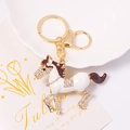 Detailed macro view of a gold-plated horse keychain inlaid with sparkling rhinestones - White