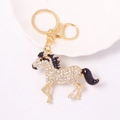 Close-up of golden horse keychain with sparkling crystal rhinestones and lobster clasp - Black