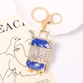 Detalle del llavero maleta de esmalte azul con cristales y acabado de metal dorado - Azul Real (6096347962191)