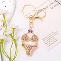 Detailed macro of a gold bikini pendant keychain with purple rhinestones and enamel bow - Purple
