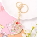 Detail of gold metal letter keychain with white rhinestones and a red heart crystal - Letter G