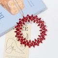 Macro detail of a red gemstone ring ornament with a gold base and grey ribbon tie - Red (Style 3)