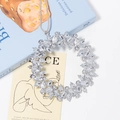 Macro detail of a sparkling rhinestone wreath pendant with a grey hanging cord - Transparent Silver (Style 1)