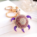 Raffinato portachiavi a tartaruga dorata con strass viola e smalto su piedistallo bianco - Viola (Colore 4)