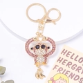 Vue détaillée du porte-clés gorille doré avec strass roses, cœur et pendentif banane - Rose