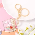 Close-up of gold metal keychain with crystal letter pendant and red heart gemstone - Letter P