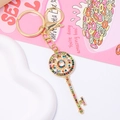 Detalle del llavero de llave dorada con pedrería de colores y cierre de langosta en rosa - Dorado Con Pedrería De Colores