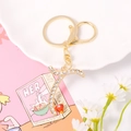 Detail of a gold-plated letter keychain with crystal rhinestones and a red heart charm - Letter T