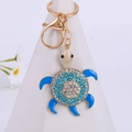 Portachiavi tartaruga blu con strass e moschettone dorato su sfondo bianco - Blu (Colore 2)