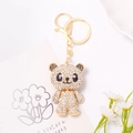 Dettaglio del portachiavi a forma di panda dorato con strass su carta decorata - Panda con Gilet Bianco