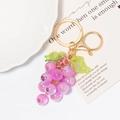 Detailed view of a purple resin grape keychain with green leaves and gold metal ring - Purple