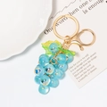 Macro detail of a cute light blue grape resin charm with golden keyring and lobster clasp - Light Blue
