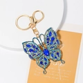Detail of blue rhinestone butterfly keychain with gold lobster clasp on gift stand - Blue