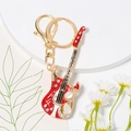 Detailed close-up of a red crystal guitar keychain with rhinestones and gold lobster clasp - Red