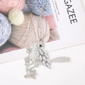 Detailed close-up of a silver rhinestone bird ornament on a branch with a hanging string - Style 2