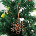 Detalle de adorno de copo de nieve de cristal ámbar colgado en el árbol con cordón marrón - Ámbar