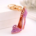 Dettaglio di strass viola e fiore su un portachiavi a forma di scarpa con tacco alto dorato - Viola