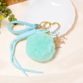 Detail of mint green leather keychain with fluffy fur ball and sparkling rhinestone letter F - Letter F / Mint Green