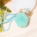 Detail of mint green pom pom keychain with blue woven cord and golden butterfly charm - Letter J / Mint Green