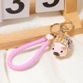 Detail eines rosa Emaille-Schweinchen-Schlüsselanhängers mit bunten Strasssteinen - Rosa Schwein Mit Geflochtener Schnur