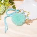 Detail of mint green faux fur pompom keychain with rhinestone letter P and butterfly - Letter P
