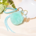 Detail of mint green pompom keychain with butterfly pendant and leather strap - Letter V