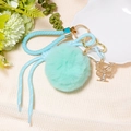 Detail of mint green pompom keychain with gold butterfly charm and woven leather strap - Letter Y
