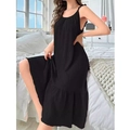 Detail of loose black slip dress featuring subtle texture and ruffled hemline trim - Black