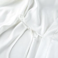 Detail of elegant white satin pajama robe featuring a delicate bow-tie waist closure - S / White