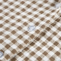 Primer plano de la textura vichy de algodón y el botón blanco del pijama - S / Cuadros Marrones y Blancos