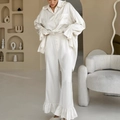 Elegante witte satijnen pyjamaset met ruches en wijde broek in een minimalistische studio - S / Boven- En Onderstuk / Beige