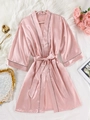 Détail d'un peignoir en satin rose pour femme avec bordure noire sur tapis en peluche - S / Rose