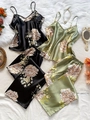 Flat lay of satin floral pajama sets in black and olive green with luxury home decor - S / Black And Green