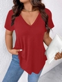 Maglietta rossa con scollo a V profondo abbinata a jeans blu e una pochette in pelle bianca - S / Rosso