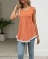 Detail of orange striped tank top featuring asymmetrical white lace trim on the hemline - Orange