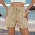 Détail d'un short en coton kaki à taille haute avec cordon et poches cargo sur la plage - Kaki