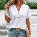 Dettaglio ravvicinato della T-shirt bianca con scollo a V e trama a nido d'ape con bottoni - Bianco