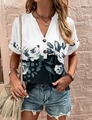 Detail of V-neck short sleeve top featuring artistic floral print and textured brown buttons - S / Black