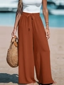 Dettaglio dei pantaloni larghi a vita alta caramello con fiocco e texture lino - Marrone chiaro