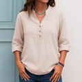 Detail of oatmeal linen shirt featuring V-neckline and natural wood buttons textures - S / Apricot