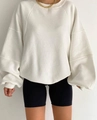 Close-up of a cream-colored oversized sweatshirt with raglan puff sleeves and gold necklace - White